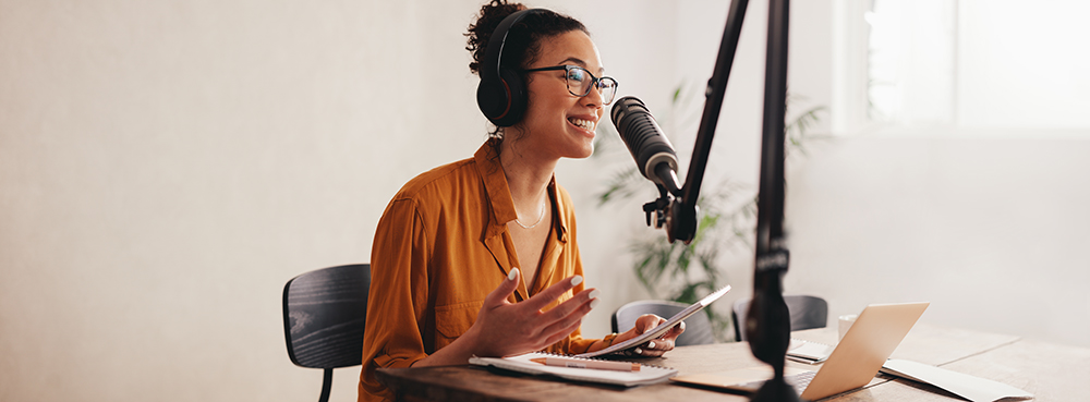 Female podcaster making audio podcast from her home studio